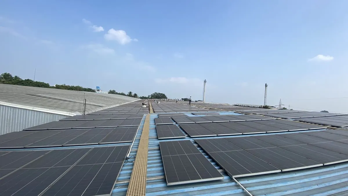 Rows of solar panels across an industrial rooftop