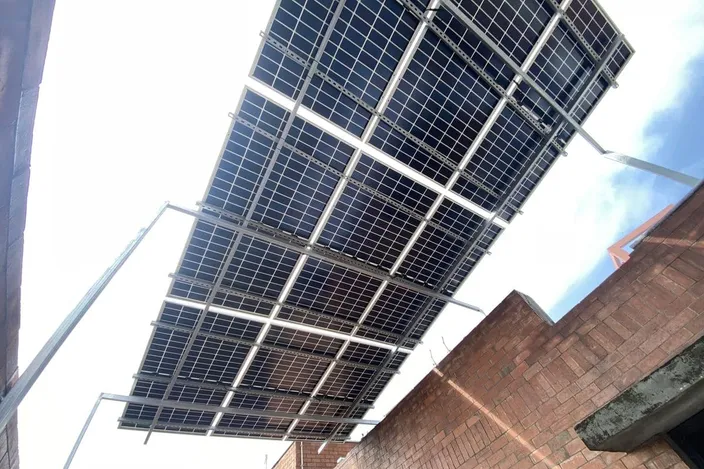 Underside of bifacial solar panels against a clear sky